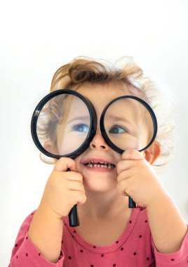 Çocuk büyüteçle dünyayı keşfediyor. Seçici odaklanma. Çocuk.