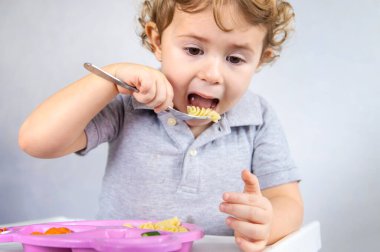 Çocuk makarna ve sebze yiyor. Seçici odaklanma. Çocuk.
