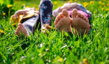 Bahar karahindiba bahçesindeki çimlerin üzerinde çocuk ayakları. Seçici odaklanma. Doğa.