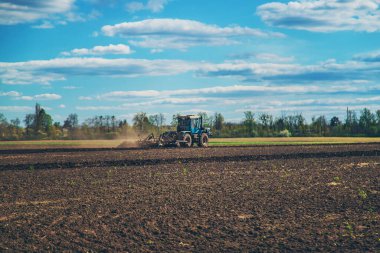 Traktör tarladaki toprağı sürer. Seçici odaklanma. Doğa.