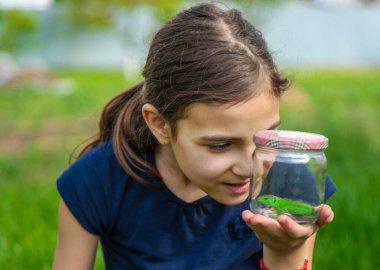Doğada bir kertenkeleyle çocuk. Seçici odaklanma. Çocuk.