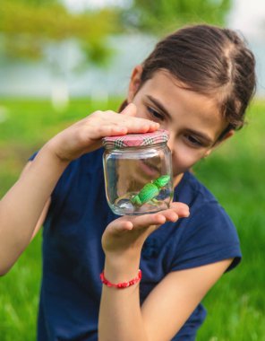 Doğada bir kertenkeleyle çocuk. Seçici odaklanma. Çocuk.