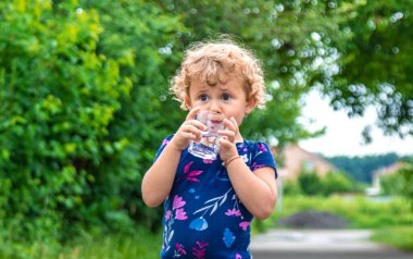 Bir çocuk bardaktan su içer. Seçici odaklanma. Yiyecek..