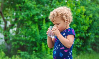 Bir çocuk bardaktan su içer. Seçici odaklanma. Yiyecek..