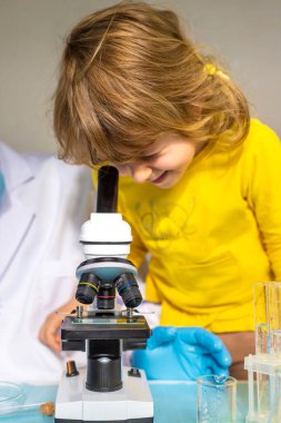 Bir çocuk mikroskoptan bakar. Seçici odaklanma. Doğa.