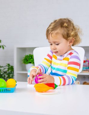 Çocuk mutfak ve yemek oyuncakları oynuyor. Seçici odaklanma. Çocuk.