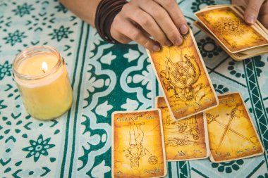 Bir falcı tarot kartlarıyla okur. Seçici odaklanma. Kadın.
