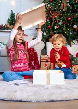 Çocuklar ağacın altındaki Noel hediyelerini açarlar. Seçici odaklanma. Çocuk.