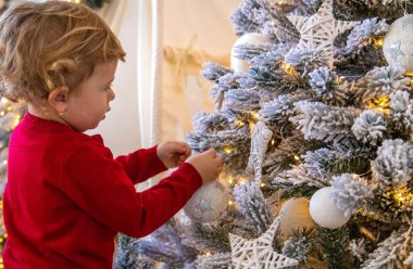 Çocuk Noel ağacına bir süs astı. Seçici odaklanma. Çocuk.