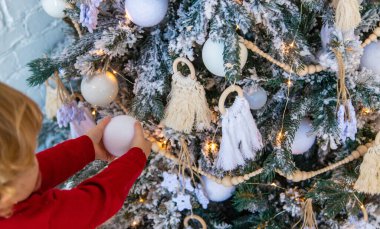 Çocuk Noel ağacına bir süs astı. Seçici odaklanma. Çocuk.