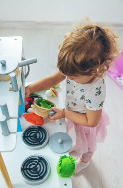 the child plays in the kitchen and cooks. Selective focus. Kid.