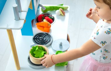 the child plays in the kitchen and cooks. Selective focus. Kid.
