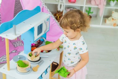 the child plays in the kitchen and cooks. Selective focus. Kid.
