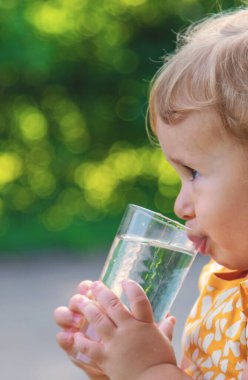 Çocuk bardaktan su içiyor. Seçici odaklanma. Çocuk.