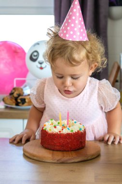 Child is two years old with a cake and candles. Selective focus. Kid.