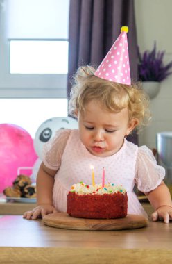 Child is two years old with a cake and candles. Selective focus. Kid.