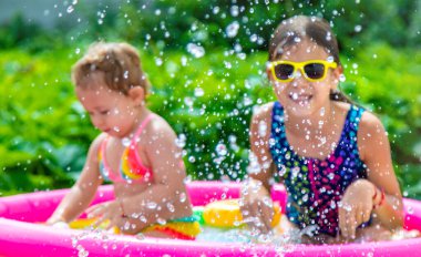 Çocuklar havuzda yüzer. Seçici odaklanma. Çocuk.