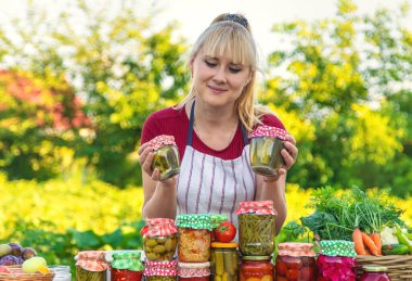 Woman with jar preserved vegetables for winter. Selective focus. Food.