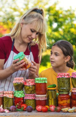 Woman with jar preserved vegetables for winter mother and daughter. Selective focus. Food.