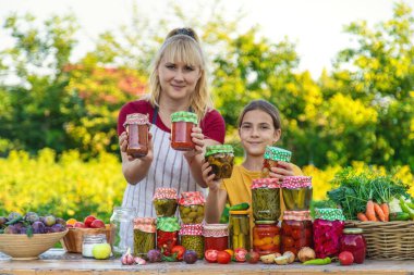 Woman with jar preserved vegetables for winter mother and daughter. Selective focus. Food.