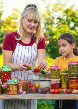 Woman with jar preserved vegetables for winter mother and daughter. Selective focus. Food.