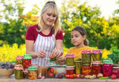 Woman with jar preserved vegetables for winter mother and daughter. Selective focus. Food.
