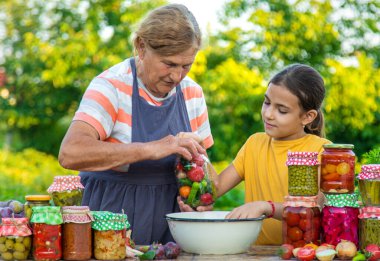 Women with jar preserved vegetables for the winter mother and daughter. Selective focus. Food.