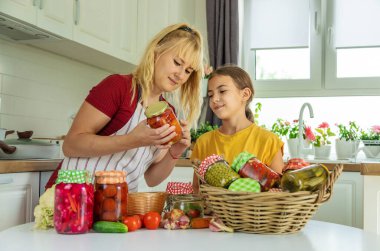 Woman with jar preserved vegetables for winter mother and daughter. Selective focus. Food.