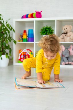 Children are reading a book in the room. Selective focus. Kid.