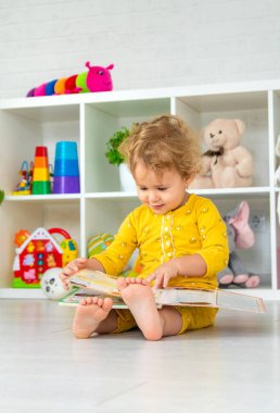 Children are reading a book in the room. Selective focus. Kid.