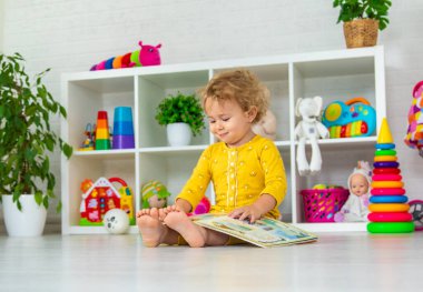 Children are reading a book in the room. Selective focus. Kid.
