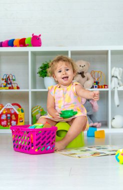 Children sit on the potty in the room. Selective focus. Kid.