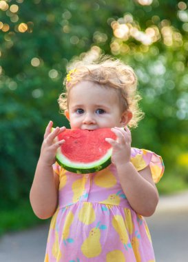 Küçük kız yazın karpuz yer. Seçici odaklanma. Yiyecek..