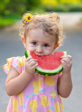 Küçük kız yazın karpuz yer. Seçici odaklanma. Yiyecek..