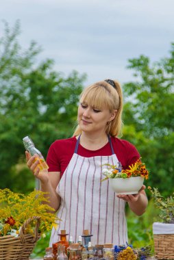 Woman with medicinal herbs and tinctures. Selective focus. Nature.