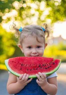 Küçük kız yazın karpuz yer. Seçici odaklanma. Yiyecek..