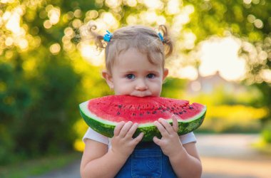 Küçük kız yazın karpuz yer. Seçici odaklanma. Yiyecek..