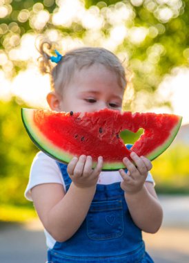 Küçük kız yazın karpuz yer. Seçici odaklanma. Yiyecek..