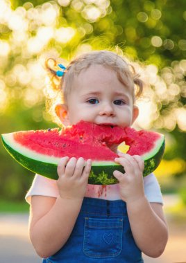 Küçük kız yazın karpuz yer. Seçici odaklanma. Yiyecek..