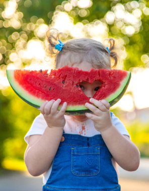 Küçük kız yazın karpuz yer. Seçici odaklanma. Yiyecek..