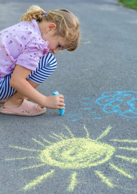 Çocuklar asfalta tebeşirle resim çiziyor. Seçici odaklanma. Çocuk.