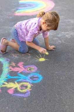 Çocuklar asfalta tebeşirle resim çiziyor. Seçici odaklanma. Çocuk.