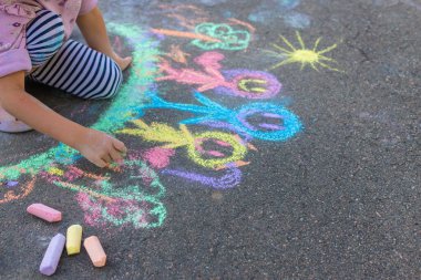 Çocuklar asfalta tebeşirle resim çiziyor. Seçici odaklanma. Çocuk.