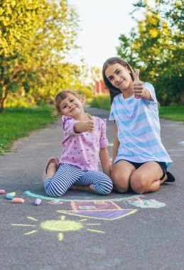 Çocuklar asfalta tebeşirle resim çiziyor. Seçici odaklanma. Çocuk.