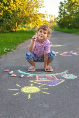 Çocuklar asfalta tebeşirle resim çiziyor. Seçici odaklanma. Çocuk.