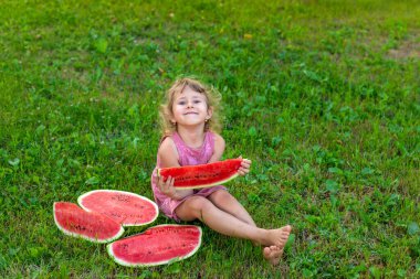 Bir çocuk parkta bir karpuz yiyor. Seçici odaklanma. Çocuk.