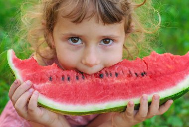 Bir çocuk parkta bir karpuz yiyor. Seçici odaklanma. Çocuk.