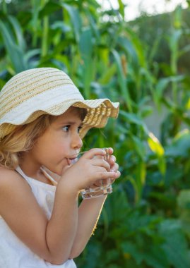 Dışarıda su içen bir çocuk. Seçici odaklanma. Çocuk.