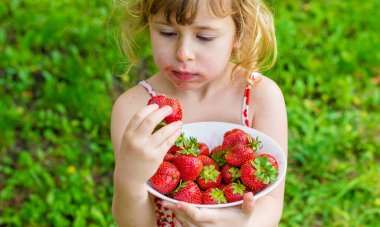 Bahçesinde çilek olan çocuk. Seçici odaklanma. Çocuk.