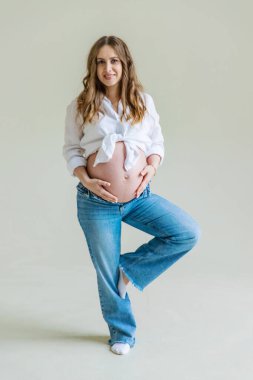 Hafif arka planda hamile bir kadın. Seçici odaklanma. Çocuk.